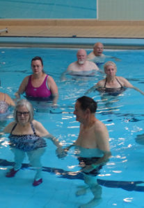 A carer supporting a member in the water
